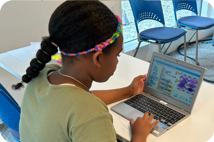 middle school girl coding on laptop