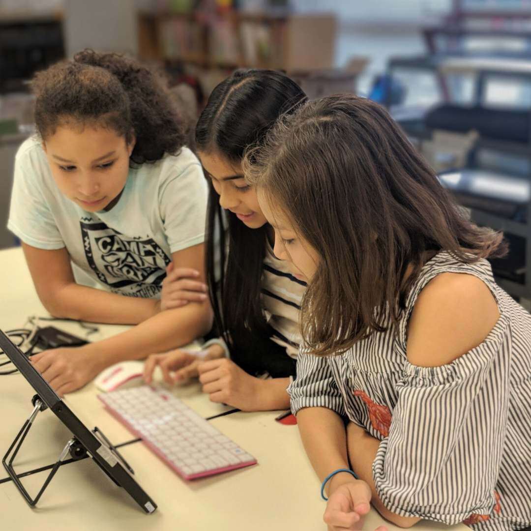 three girls looking at microbit